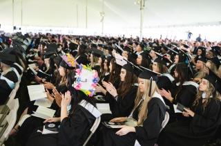 Audience of undergrad students in caps and gowns at Commencement